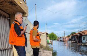 Dois Homens na beira de rua alagada em Parnaíba Pìauí