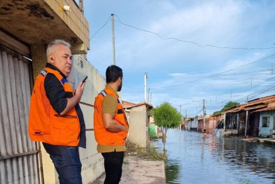 Dois Homens na beira de rua alagada em Parnaíba Pìauí